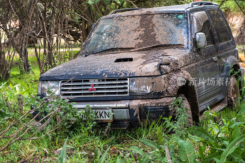 越野车三菱帕杰罗陷在泥里。沼泽里肮脏的越野车。探险旅游的概念。4 × 4越野车陷入泥潭。旅行,旅游的概念。